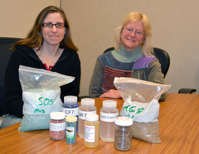 Photo of Tara Carson and Kathleen Schaefer looking at salt and other chemicals. 